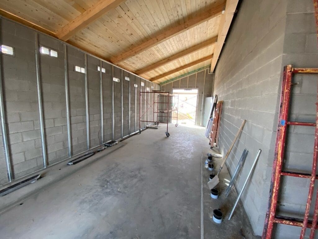 Interior view showing completed roof decking and exposed wall framing on masonry walls during ongoing construction at the City of Surprise Foothills Water Campus