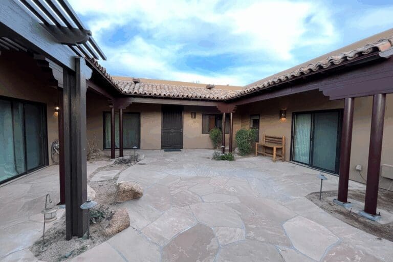 Existing courtyard patio at the Fountain Hills Patio project, featuring natural stone paving, covered walkways, and Southwestern-inspired architectural detailing prior to landscape and finish upgrades.