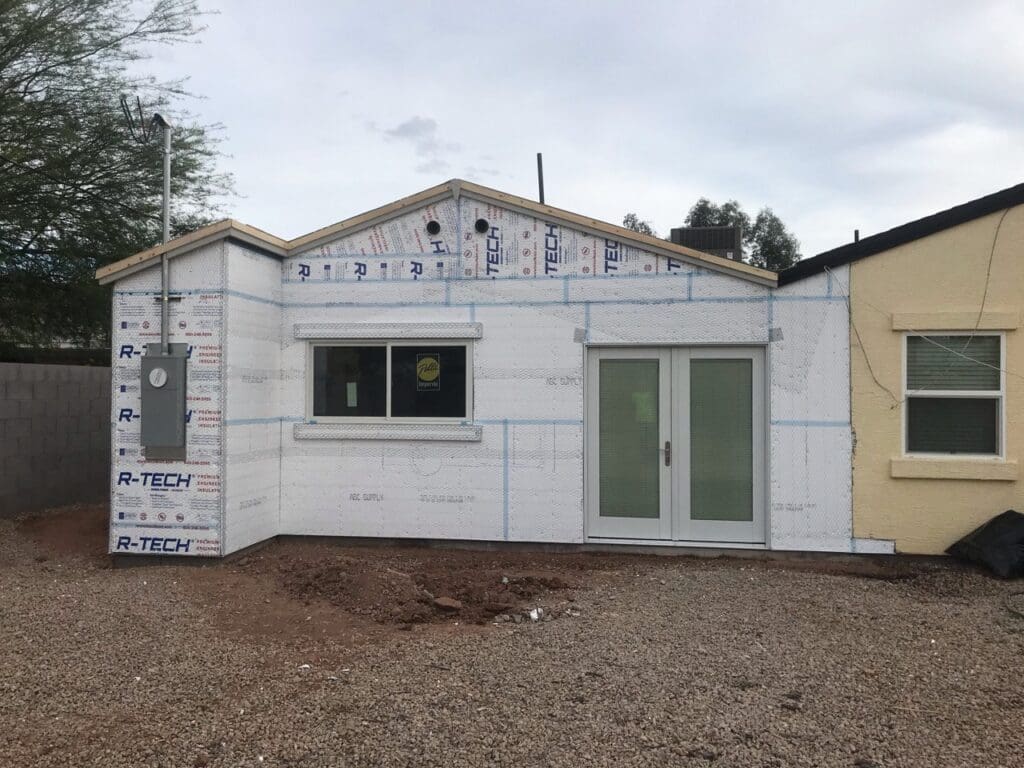 Completed exterior sheathing and insulation wrap on new home addition before stucco application.